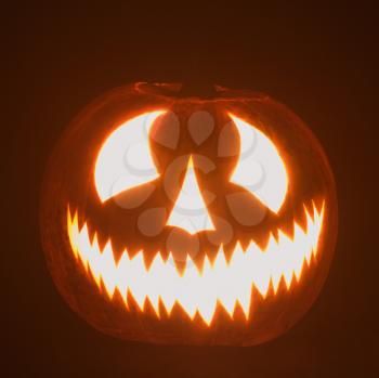 Royalty Free Photo of a Carved Halloween Pumpkin Glowing in the Dark