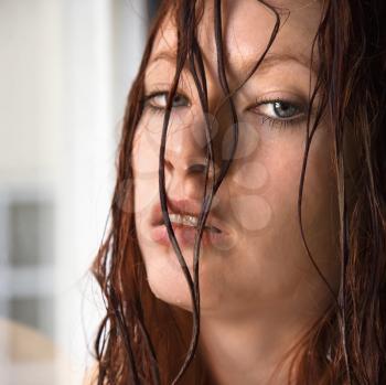 Royalty Free Photo of a pretty young redhead woman with wet hair hanging in face