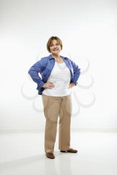 Royalty Free Photo of a Middle-aged Woman Standing With Hands on Hips Smiling