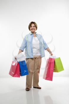 Royalty Free Photo of a Woman Holding Gift Bags and Smiling