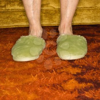 Royalty Free Photo of an Older Female's Feet Wearing Green Bedroom Slippers