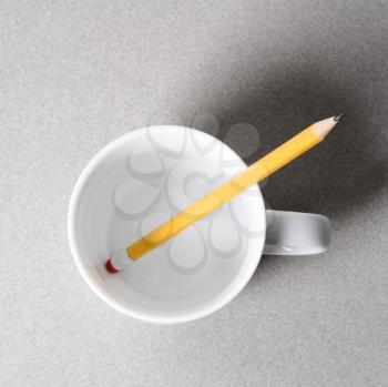Royalty Free Photo of a Pencil in a Coffee Cup