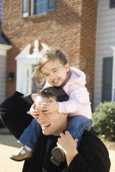 Royalty Free Photo of a Father Carrying His Daughter on His Shoulders