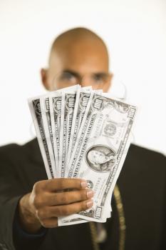 African American man in suit holding cash.