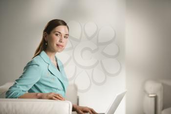 Royalty Free Photo of a Professional Businesswoman Sitting in an Office Working on a Laptop Computer 