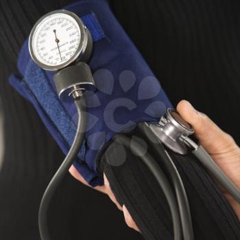 Royalty Free Photo of a Doctor Testing a Patient's Blood Pressure