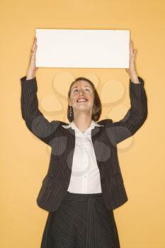 Royalty Free Photo of a Businesswoman Holding Up a Sign