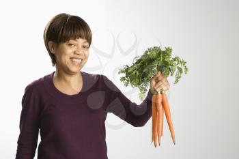 Royalty Free Photo of a Woman Holding a Bunch of Carrots