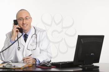 Royalty Free Photo of a Physician Sitting at a Desk With a Computer