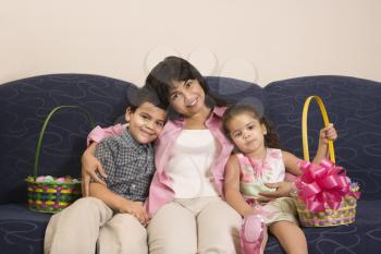 Royalty Free Photo of a Mother With Her Son and Daughter at Home Sitting With Easter Baskets