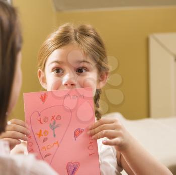 Royalty Free Photo of a Girl Giving Her Mother a Drawing