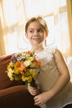 Caucasian girl smiling holding bouquet of flowers.