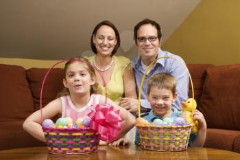 Caucasian family with Easter baskets looking at viewer. 