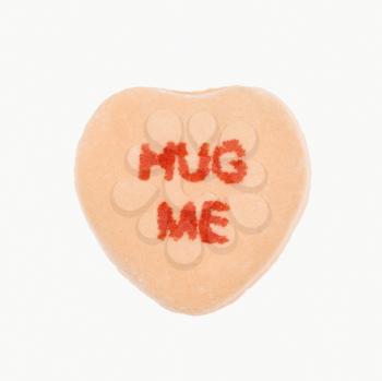 Royalty Free Photo of an Orange Candy Heart That Reads Hug Me