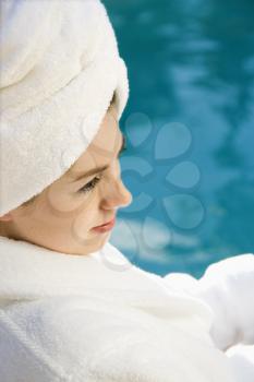 Royalty Free Photo of a Woman a Wearing Robe and Towel Sitting Next to a Pool