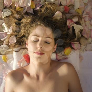 Royalty Free Photo of a Woman Lying Down With Rose Petals in Her Hair