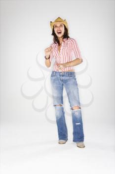 Young adult Caucasian woman wearing cowboy hat laughing.