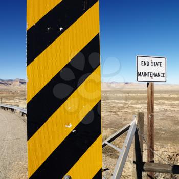 Royalty Free Photo of a Yellow and Black Caution Sign With Utah Landscape in the Background