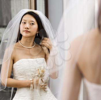 Royalty Free Photo of an Asian Bride Looking at Herself in a Mirror