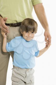 Royalty Free Photo of a Boy Holding onto His Father's Hands Standing Against a White Background