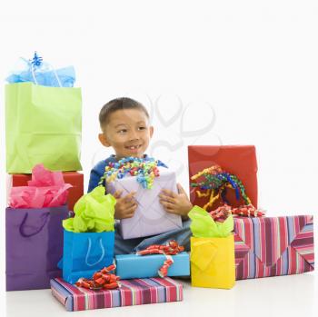 Royalty Free Photo of a Boy Sitting Smiling With Wrapped Presents