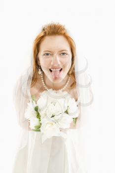 Royalty Free Photo of Bride Holding a Bouquet and Sticking Her Tongue Out