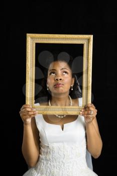 Royalty Free Photo of a Bride Holding a Frame Around Her Face