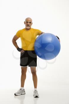 Royalty Free Photo of a Man Standing and Holding a Blue Exercise Ball