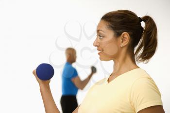 Royalty Free Photo of a Man and Woman Exercising With Dumbbells Doing Bicep Curls