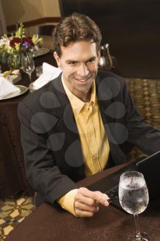 Royalty Free Photo of a Businessman With a Laptop in a Restaurant