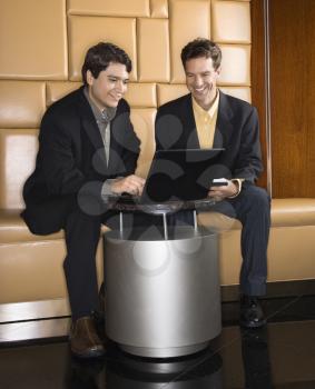 Businessmen  talking and viewing laptop computer.