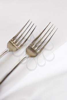 Royalty Free Photo of a Salad Fork and Dinner Fork on a White Table Cloth
