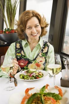 Royalty Free Photo of an Older Woman Eating a Meal and Smiling