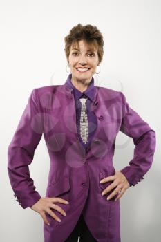 Half length portrait of pretty middle aged Caucasian woman wearing purple suit with rhinestone necktie.