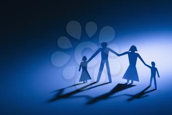 Royalty Free Photo of Paper Cutout Family of Four Standing Holding Hands