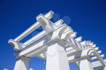 Royalty Free Photo of a Detail of a White Arbor Against a Blue Sky