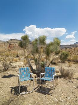 Royalty Free Photo of Empty Lawn Chairs in a Desert Landscape