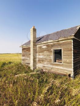 Royalty Free Photo of the Side of a Wooden Dilapidated Building in a Rural Field