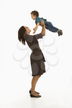Royalty Free Photo of a Mom Lifting Happy Toddler Son into Air Above Her Head