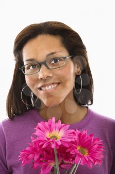 African American mid adult woman wearing glasses holding pink flowers and smiling at viewer.
