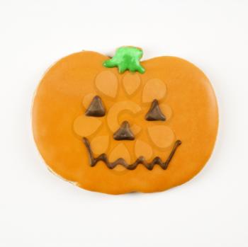 Sugar cookie in shape of jack o lantern with decorative icing.