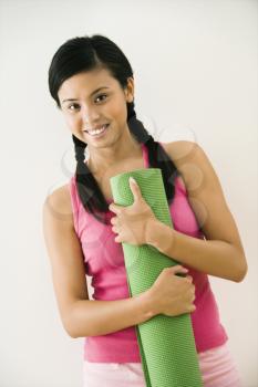 Royalty Free Photo of a Woman Holding an Exercise Mat Smiling