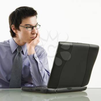 Royalty Free Photo of a Businessman Sitting at a Desk Working on a Laptop