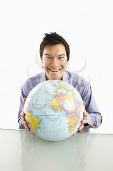 Royalty Free Photo of a Man Sitting Holding a Globe and Smiling