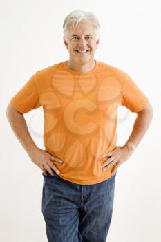 Royalty Free Photo of a Smiling Man Standing With Hands on His Hips