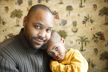 Portrait of african american father holding his young son and looking at viewer.  Horizontal shot.