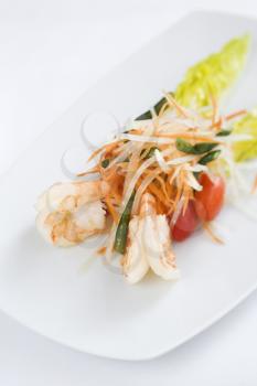 Gourmet seafood dish elegantly displayed on a white dish in an upscale restaurant. Vertical shot.
