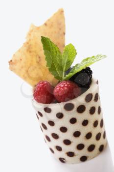 Elegant display of a dessert fruit cup with mint leaves. Vertical shot.