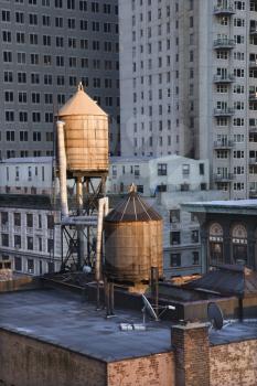 Cropped view of buildings in New York City and rooftop water towers. Vertical shot.