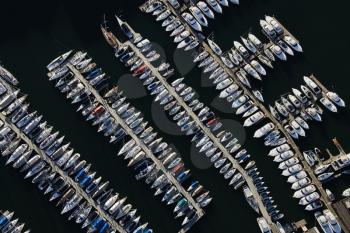 Aerial view of boats lined up on the piers at a marina. Horizontal shot.